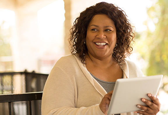 woman smiling holding tablet