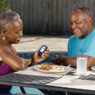 woman checking glucose monitor