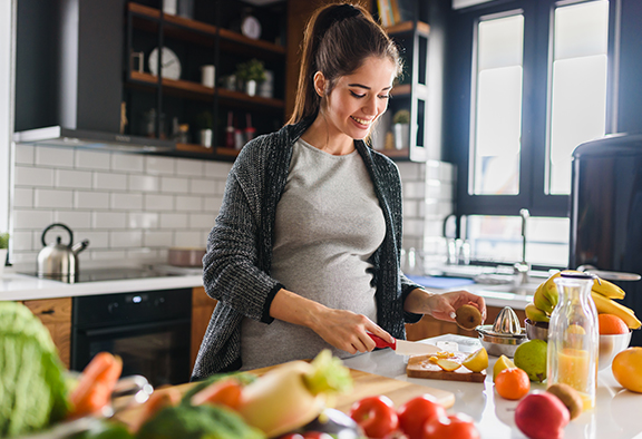 pregnant woman cutting fruit