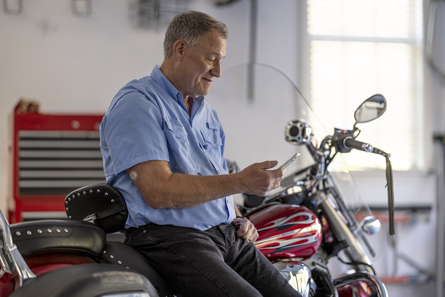 man with g7 cgm leaning motorcycle