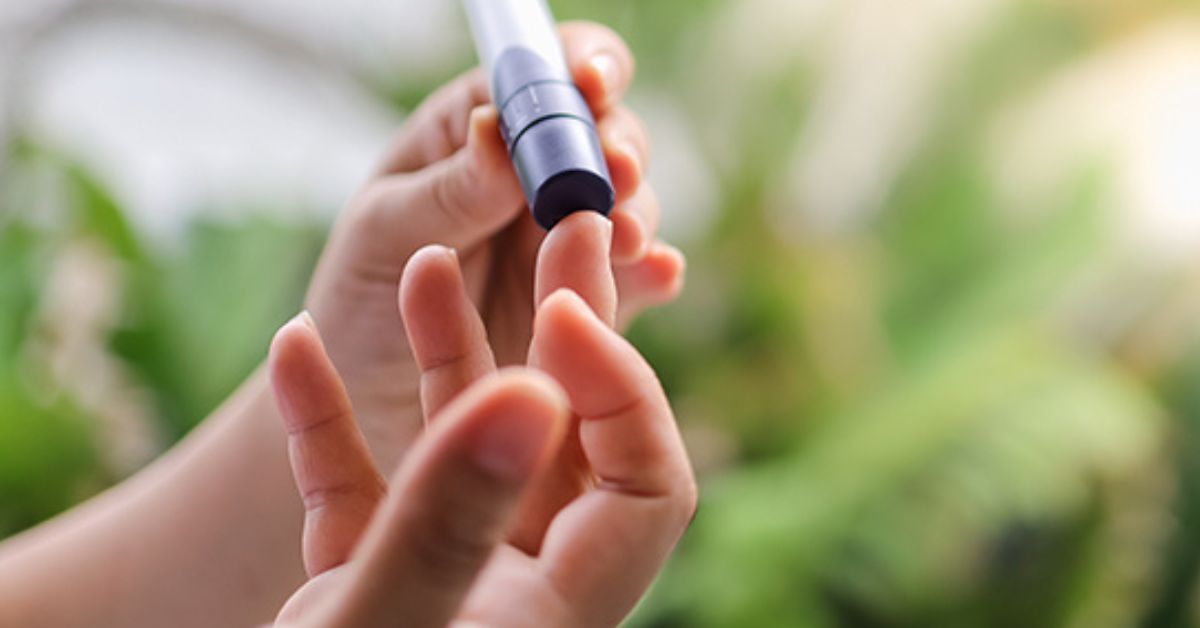 closeup image of a person performing a fingerstick test on themselves